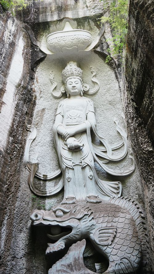 Free Intricate Buddha sculpture carved into rock with dragon design, showcasing artistry. Stock Photo