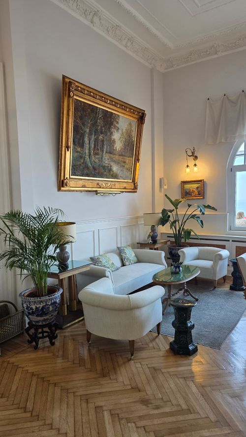 Free Elegant living room with classic decor, art painting, and lush plants. Stock Photo