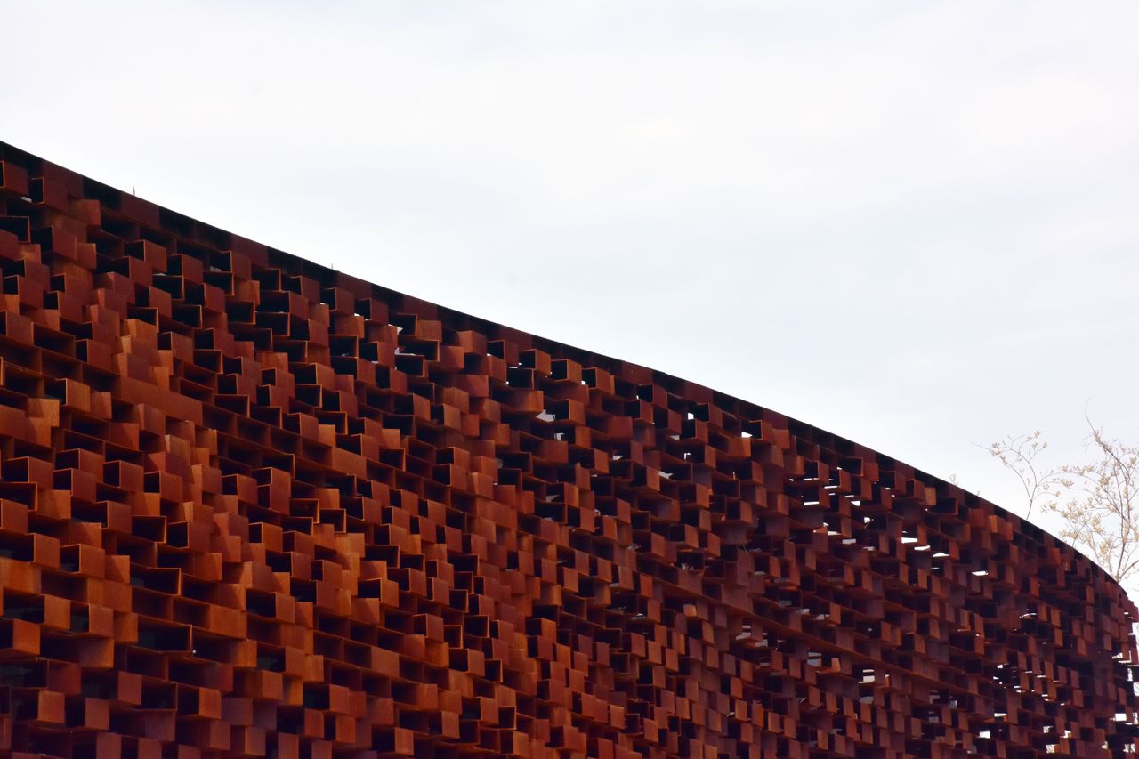 Rust-coloured Corten steel panel wall with a textured geometric surface
