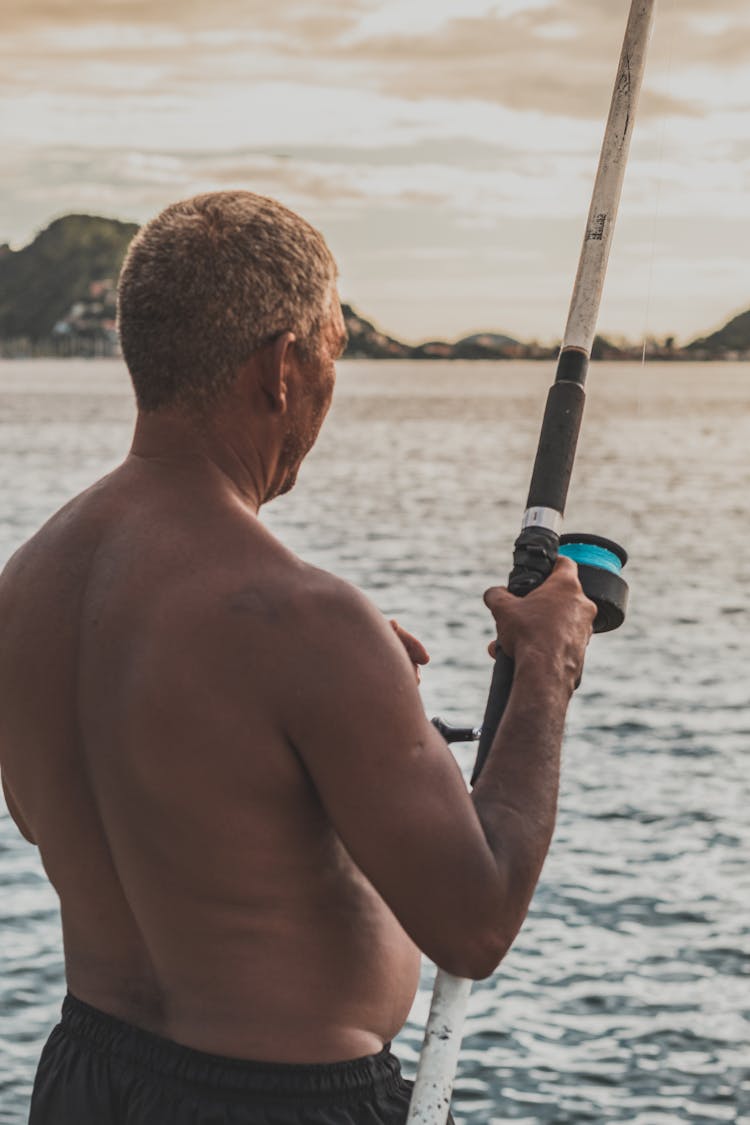 Unrecognizable Man With Fishing Rod On Pier