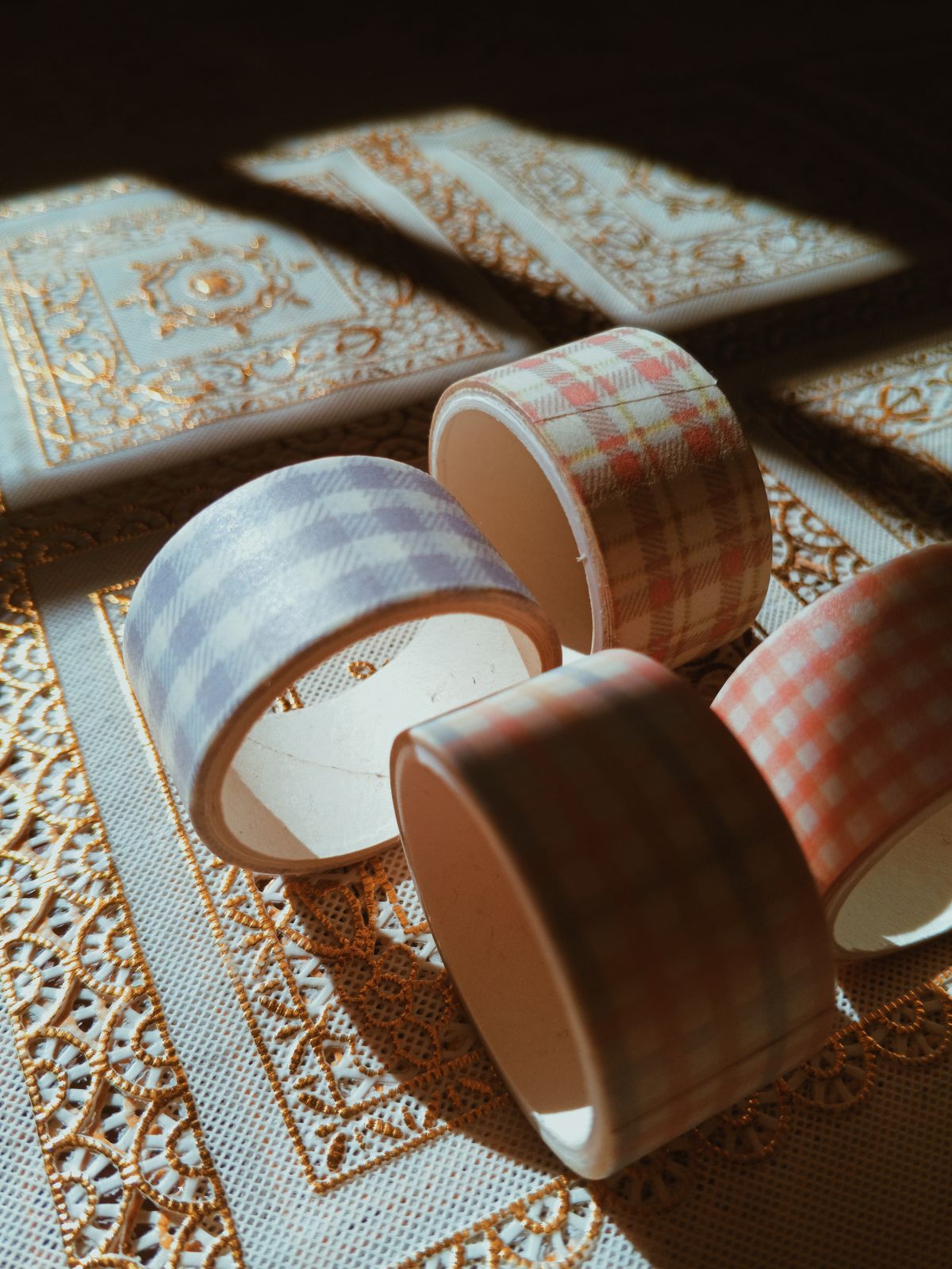 Colorful tape rolls casting shadows in sunlight for making holiday ornaments