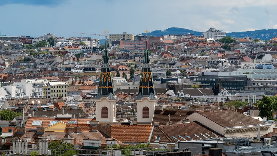 Skyline of Vienna, Austria with historical architecture and two church spires in view.