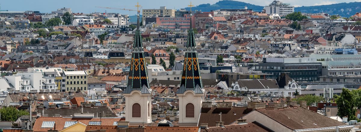 Skyline of Vienna, Austria with historical architecture and two church spires in view.