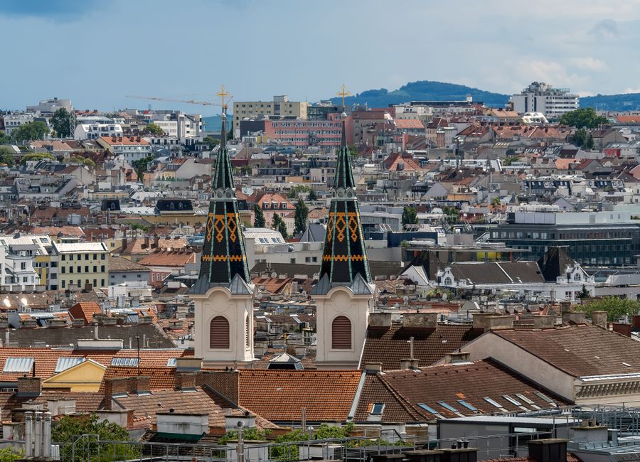 Skyline of Vienna, Austria with historical architecture and two church spires in view.