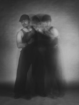 Black and white portrait of a man with motion blur, creating a dynamic artistic effect.