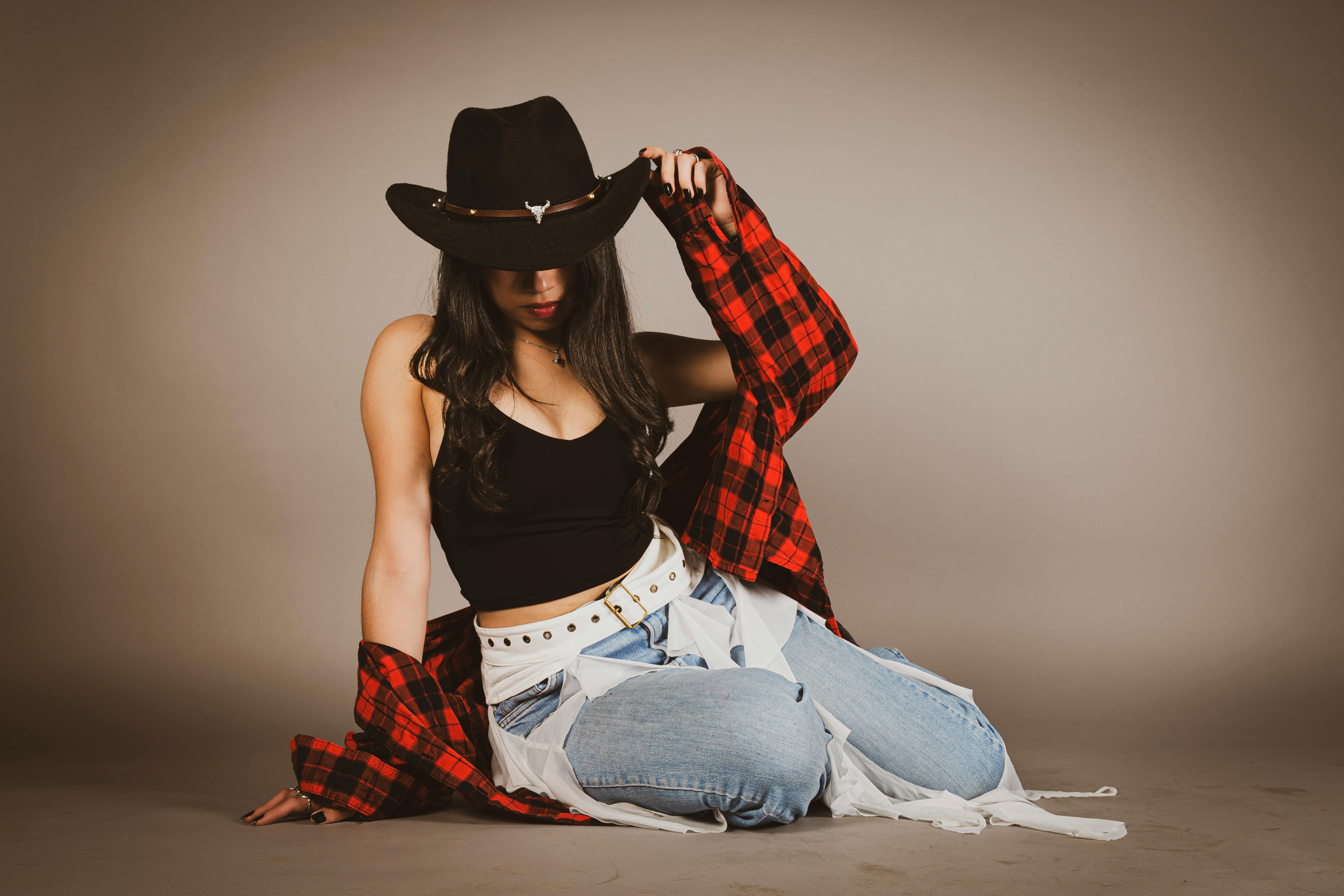 A complete western outfit featuring a tooled leather belt, denim, and cowboy boots