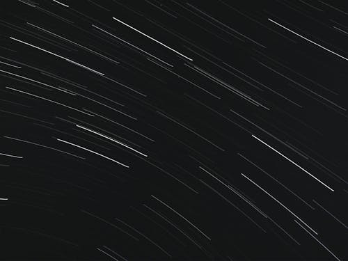 Free From below of bright glowing stars in long exposure on dark night sky Stock Photo