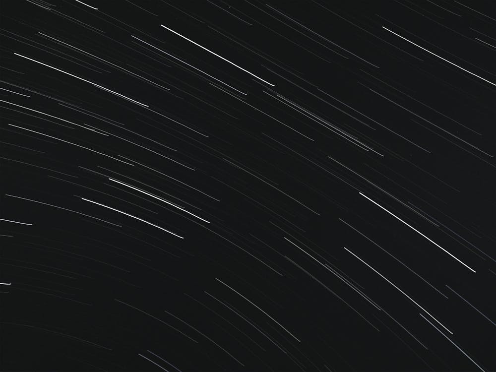 Free From below of bright glowing stars in long exposure on dark night sky Stock Photo