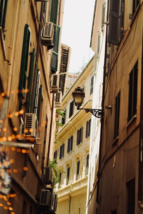 Free Explore a picturesque narrow street in Italy, adorned with window shutters and atmospheric lighting. Stock Photo