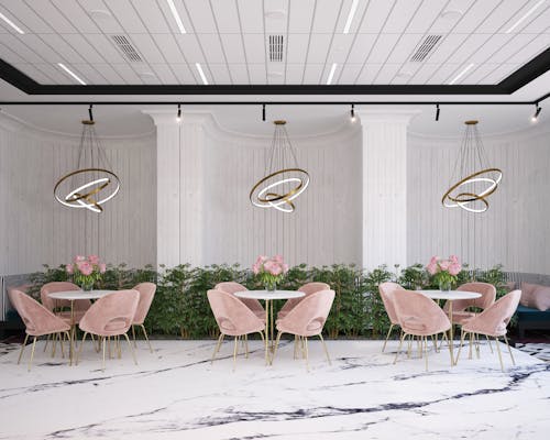 Interior of contemporary cafe with round tables and comfortable light pink armchairs with delicate flowers in glass vases