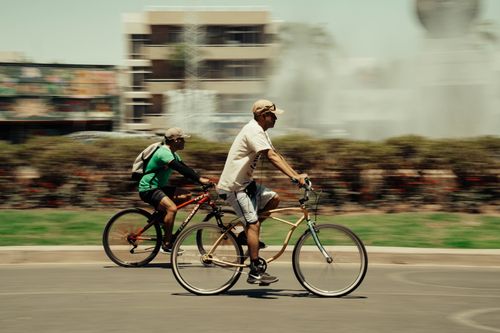 Free Two cyclists enjoying a sunny ride in Guadalajara, Mexico cityscape. Stock Photo