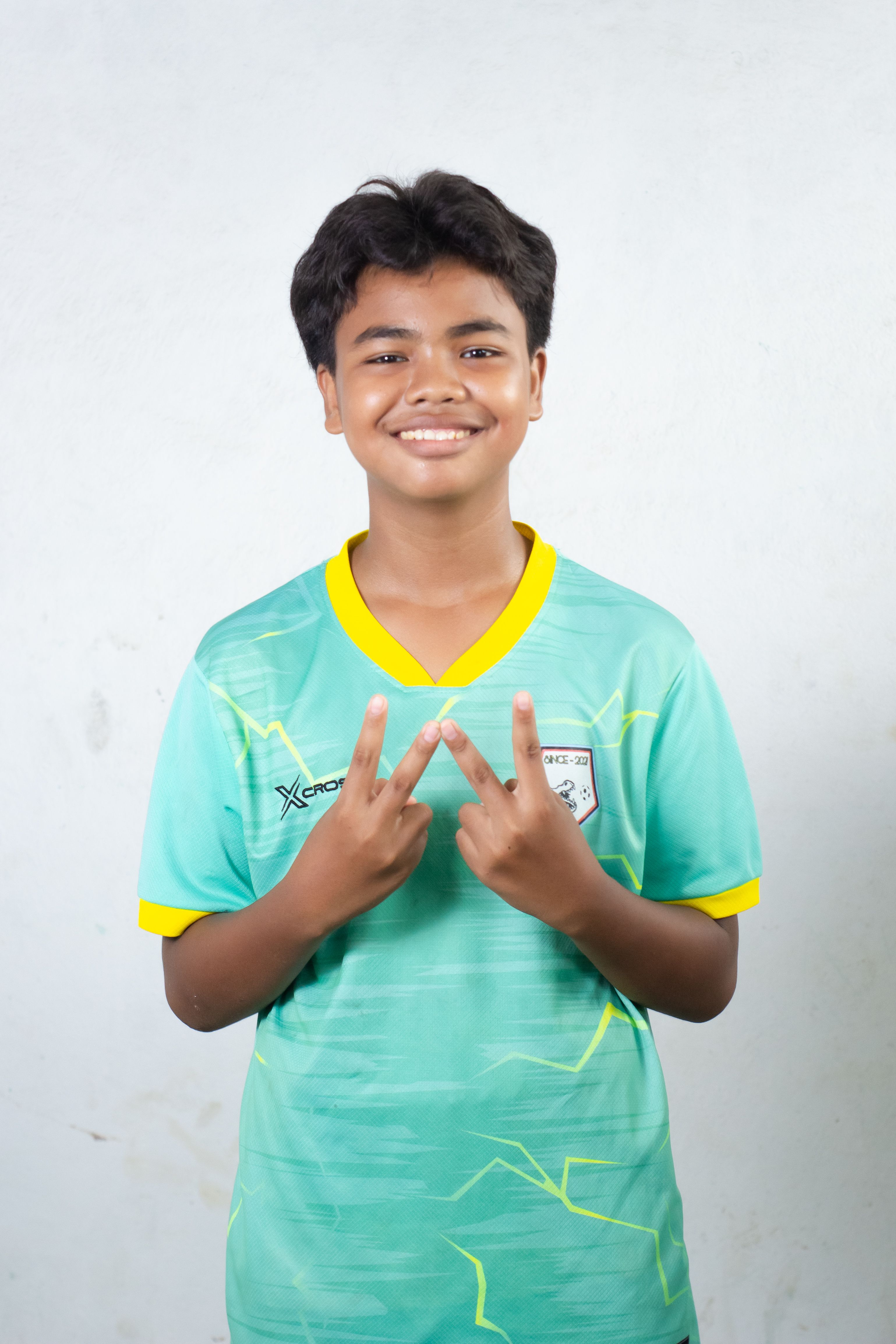 Smiling Teen Boy in Green Soccer Jersey Indoors