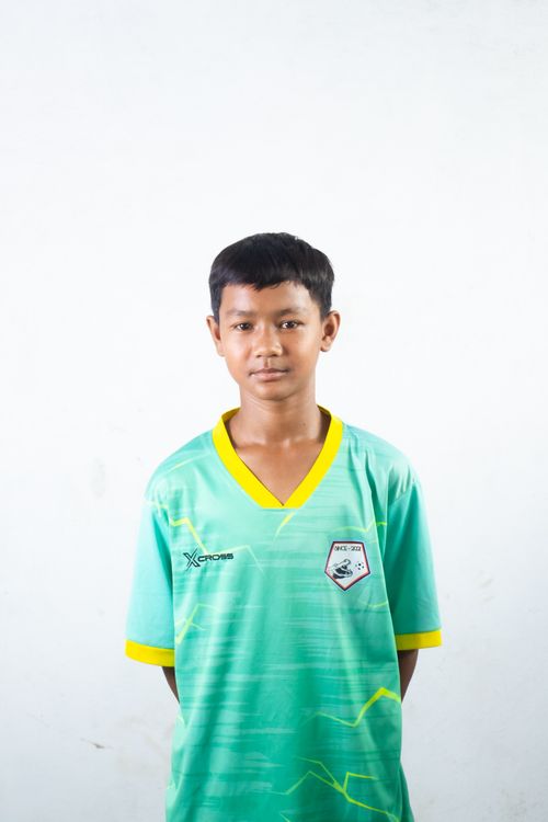 Free A young boy stands confidently in a green sports jersey against a white background. Ideal for youth sports and portraits. Stock Photo