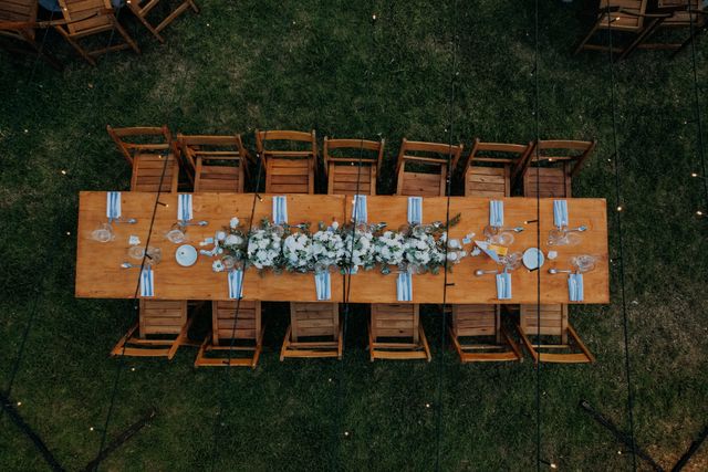 Table de réception rustique dressée en extérieur avec compositions florales