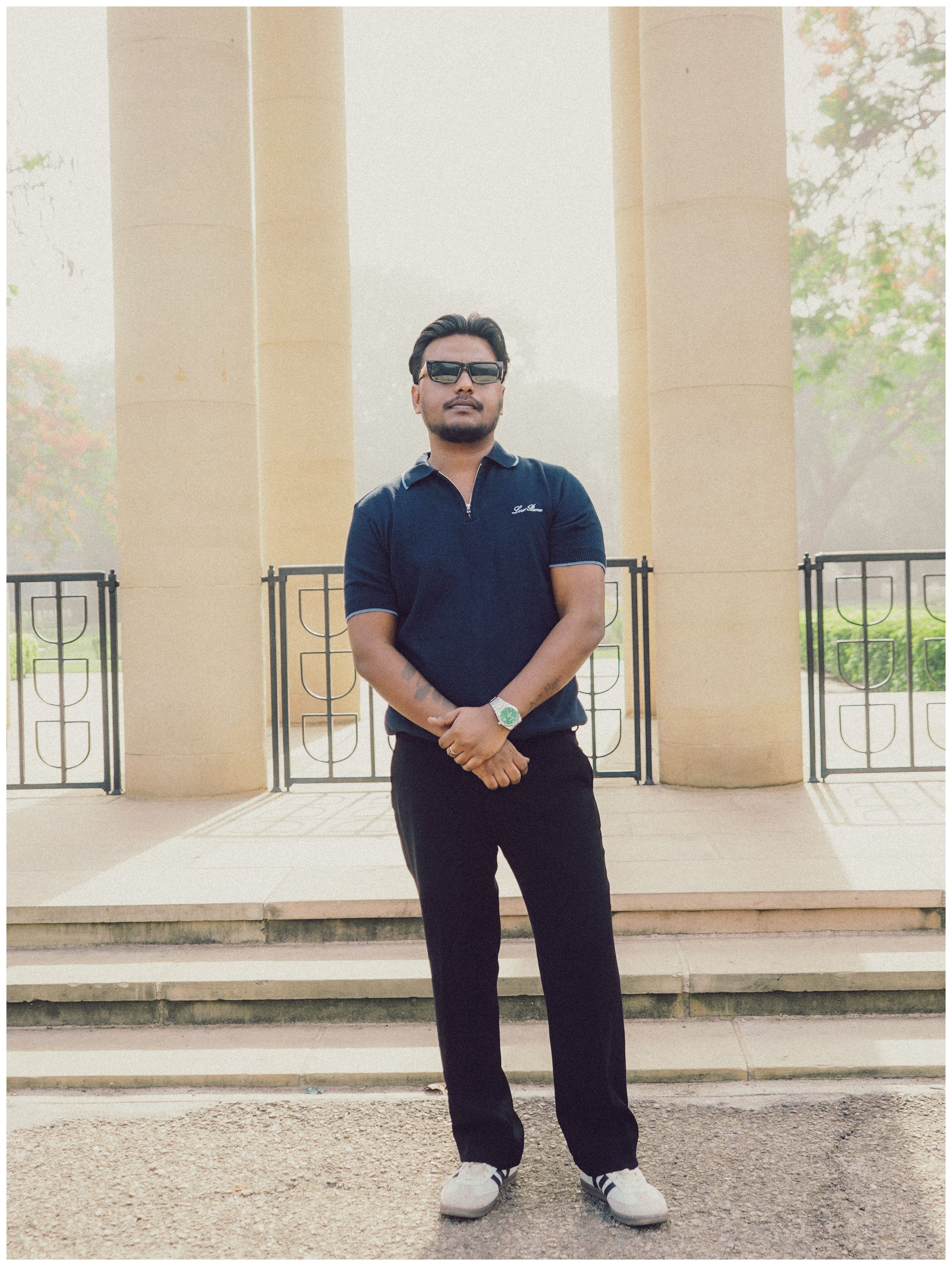 Casual portrait of a man standing outdoors on a sunny day.
