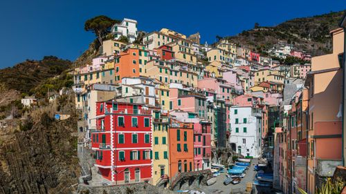 Free Vibrant houses of Riomaggiore, Cinque Terre, Italy, depicting unique architecture against a clear blue sky. Stock Photo