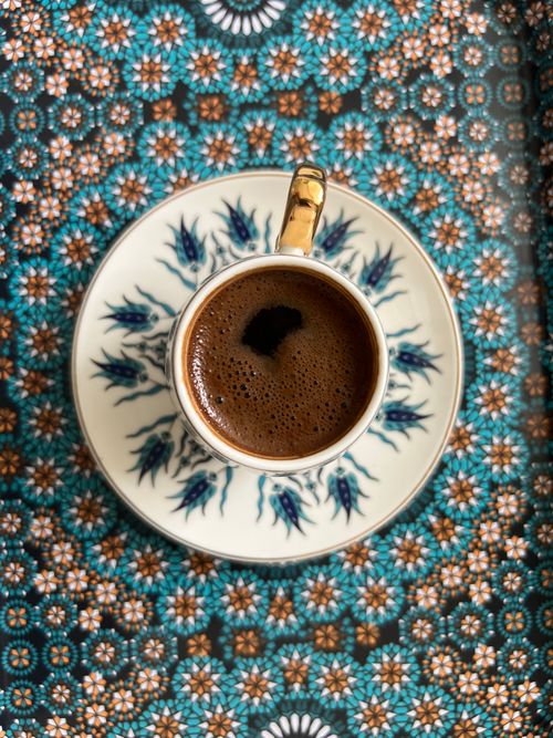 Free A top view of coffee in an intricately designed cup on a vibrant patterned tray. Perfect for lifestyle themes. Stock Photo