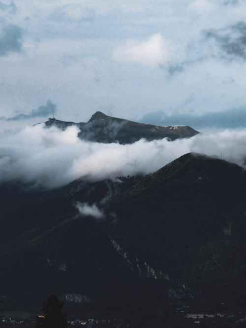 Free Dramatic mountain peaks surrounded by mist and clouds, evoking mystery and tranquility. Stock Photo