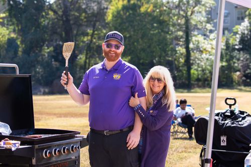 Free A joyful couple grilling at an outdoor BBQ event, enjoying a sunny afternoon. Stock Photo