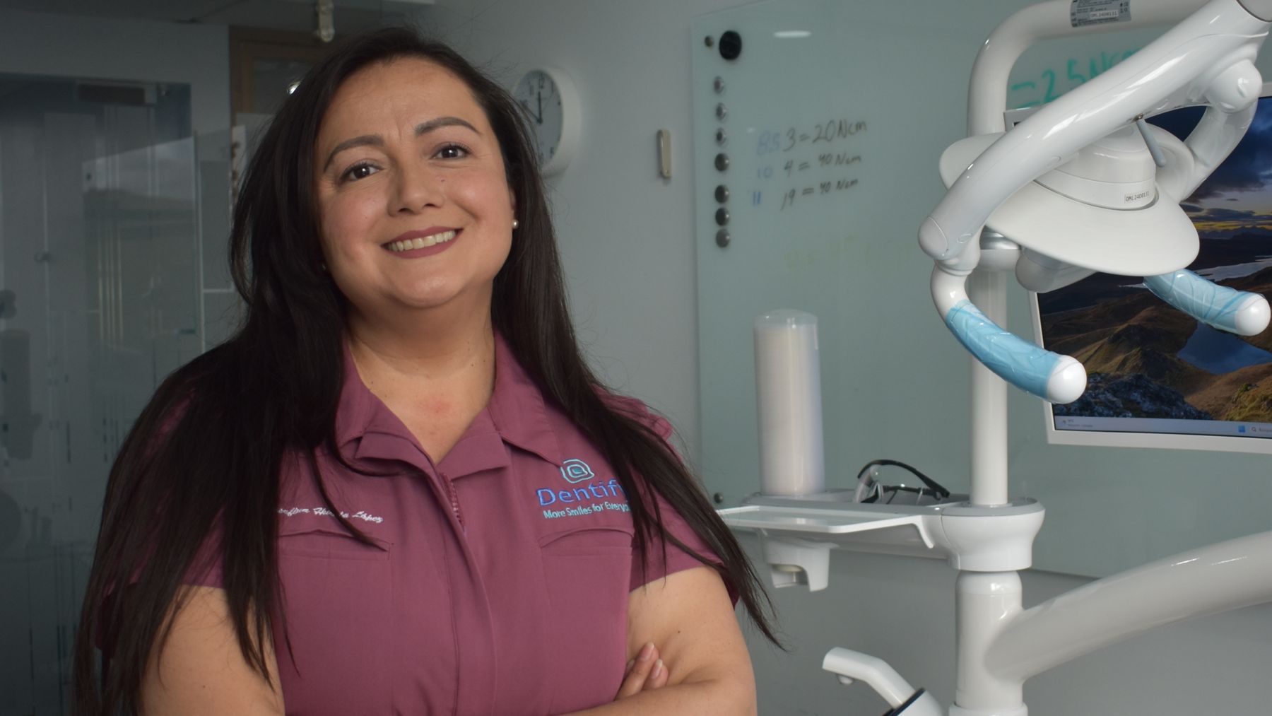 Smiling female dentist standing in a bright modern dental practice