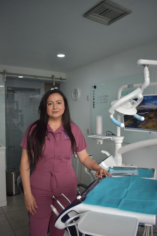 Free Female dentist in a modern clinic standing by equipment, ready to work. Stock Photo