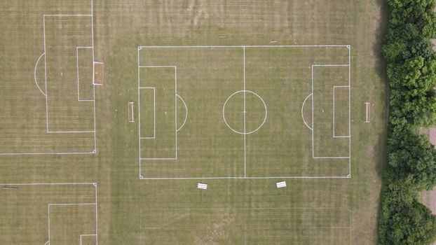 Aerial photograph showing multiple empty soccer fields with white lines on green grass.