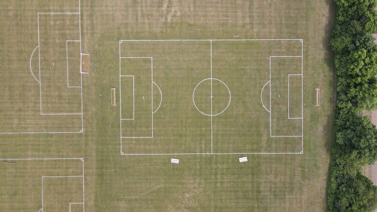 Futbol sahası üstten görünüm, yeşil çim ve beyaz çizgiler