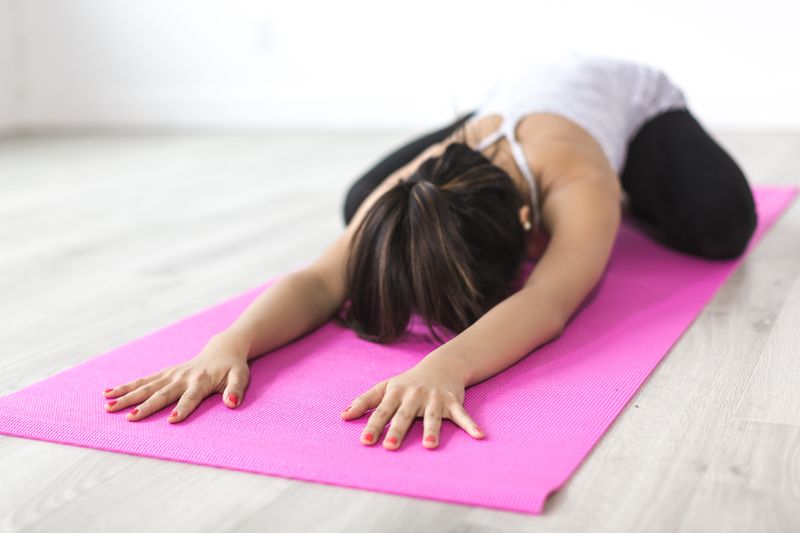 Woman in child's pose on yoga mat