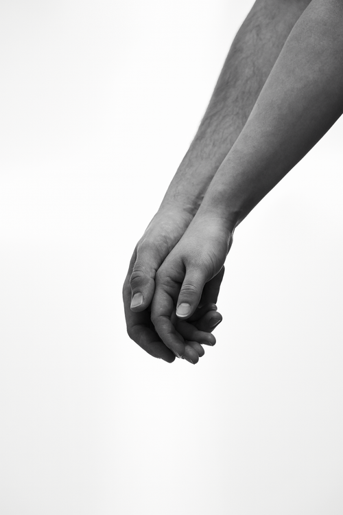 Free Artistic black and white photograph capturing a tender moment of two people holding hands. Stock Photo