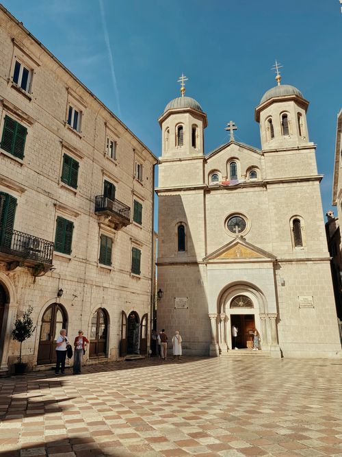 Free Beautiful architecture of an Orthodox church in Kotor's old town with people and clear sky. Stock Photo
