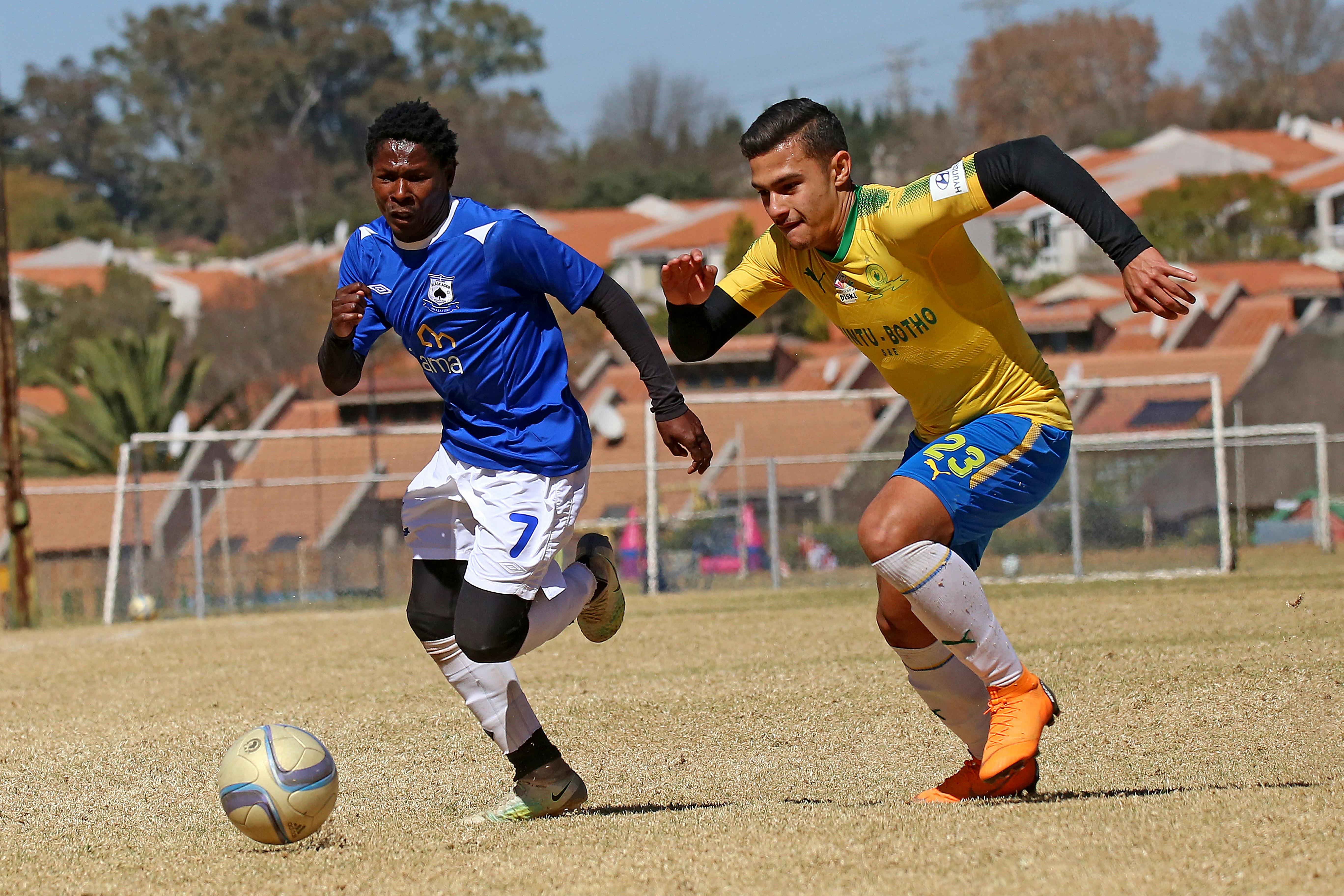 Foto Homem em calções amarelos segurando bola de futebol amarela e