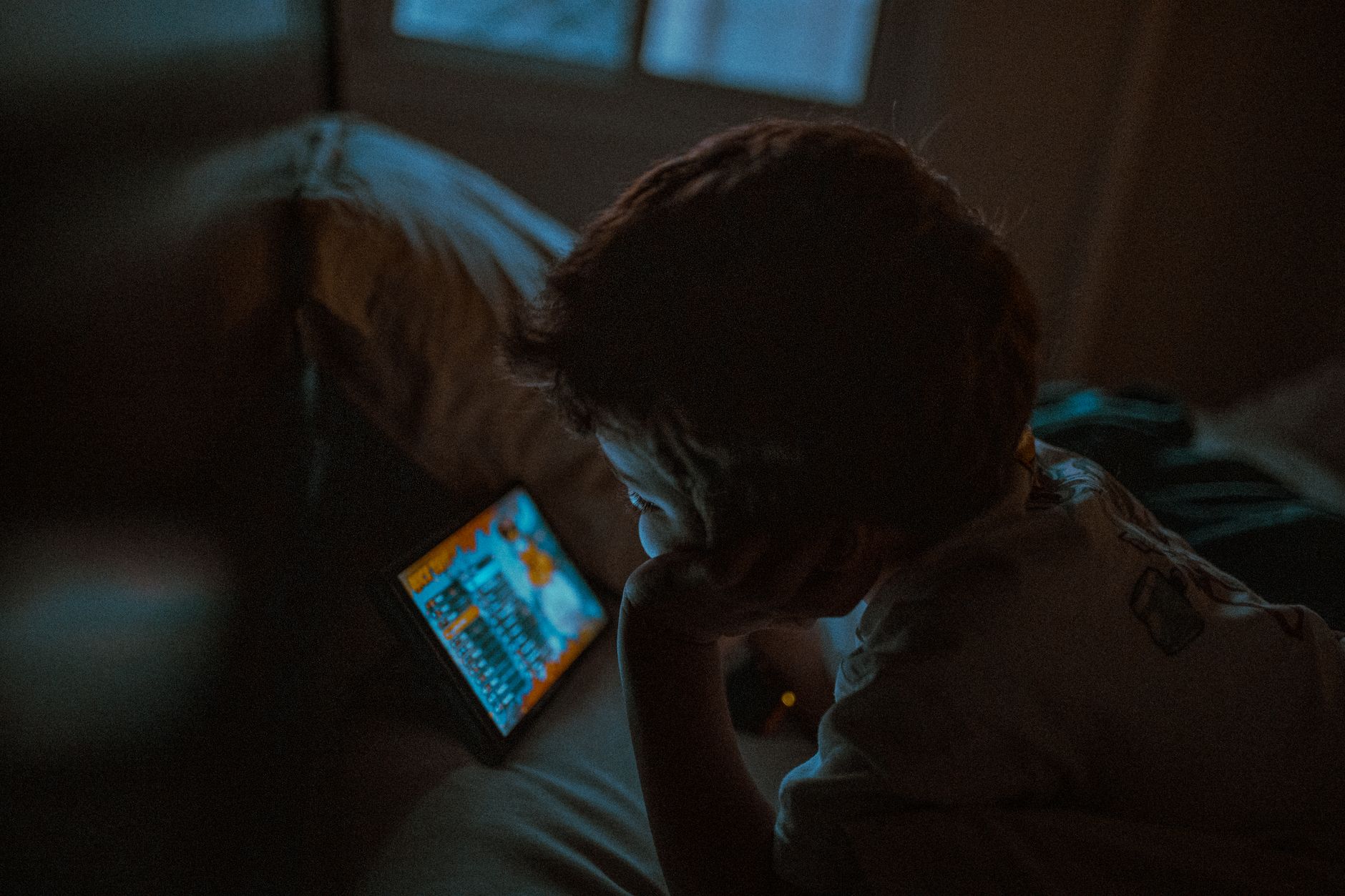 Person using phone in grayscale mode with a mindfulness journal on the desk beside them