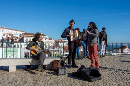Free A lively street performance with musicians in Lisbon's scenic overlook, Alfama. Stock Photo