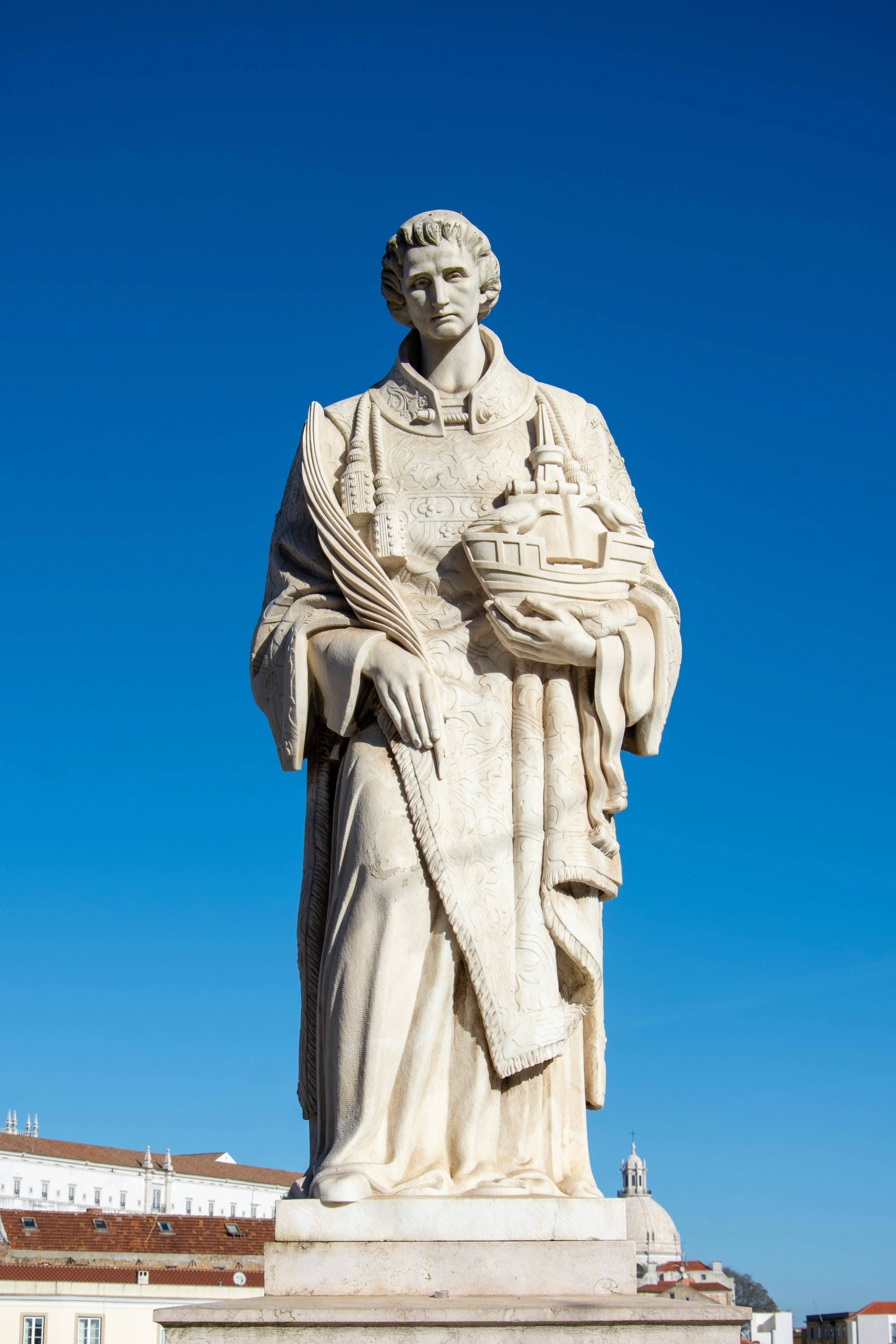 Statue of Saint Vincent in Lisbon with blue sky backdrop, symbolizing heritage and culture.