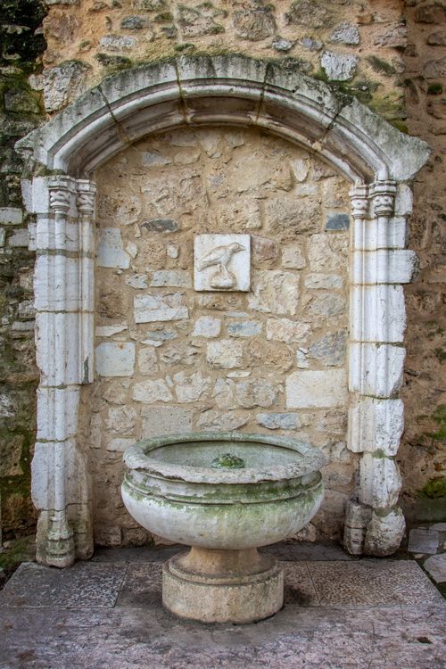 Free Ancient stone fountain with archway in Lisbon, showcasing classic architecture. Stock Photo