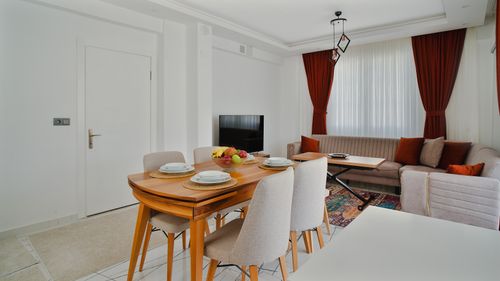 Free Spacious dining room featuring contemporary furniture, decorative curtains, and balanced lighting for a cozy ambiance. Stock Photo