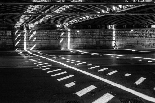Free Striking light and shadow patterns create a dramatic scene under an urban overpass. Stock Photo