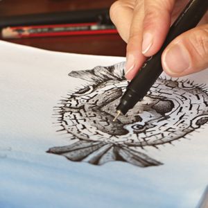 Inking a detailed drawing of a pufferfish with a fine pen