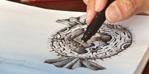 Inking a detailed drawing of a pufferfish with a fine pen