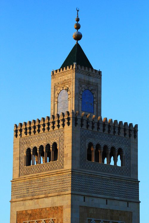 Free Capture of a historic minaret with intricate details under a clear blue sky at sunrise. Stock Photo