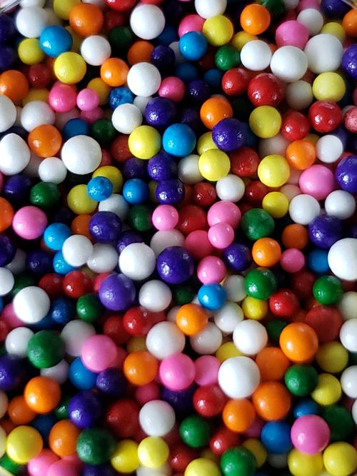 Free Vibrant and colorful candy balls arranged closely, showcasing a festive and playful theme. Stock Photo