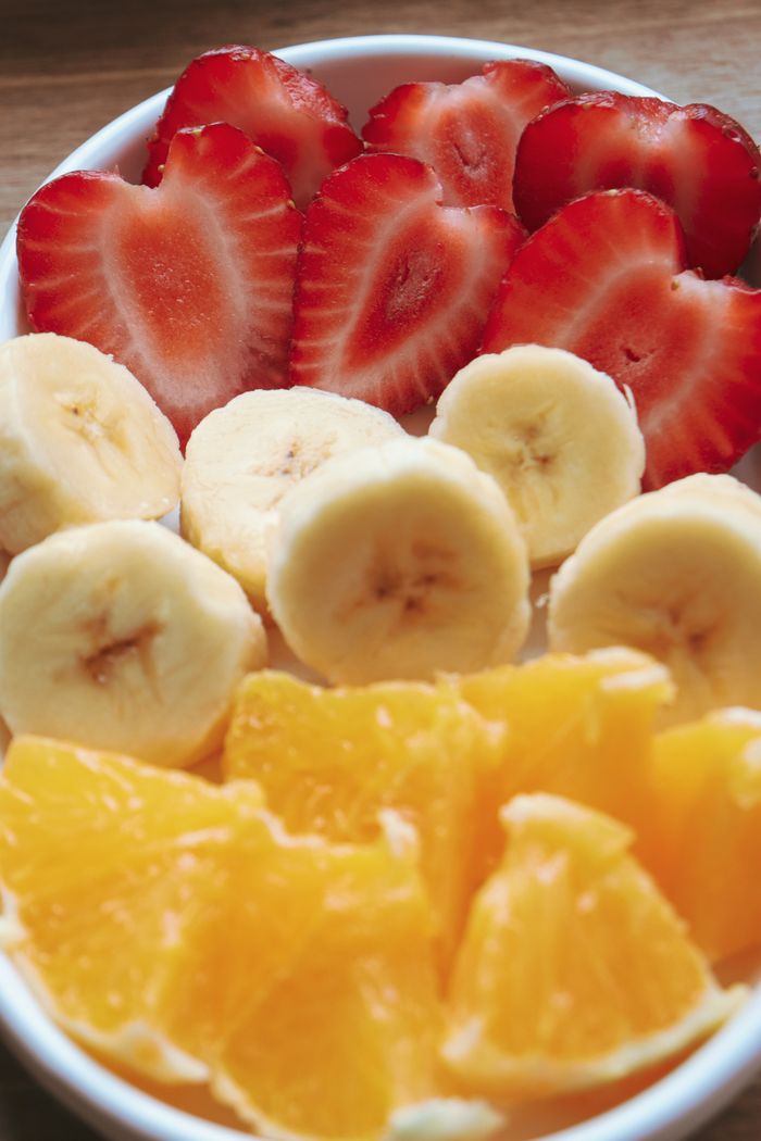 Fraises rouges, bananes et oranges dans un bol de fruits, photo d’illustration