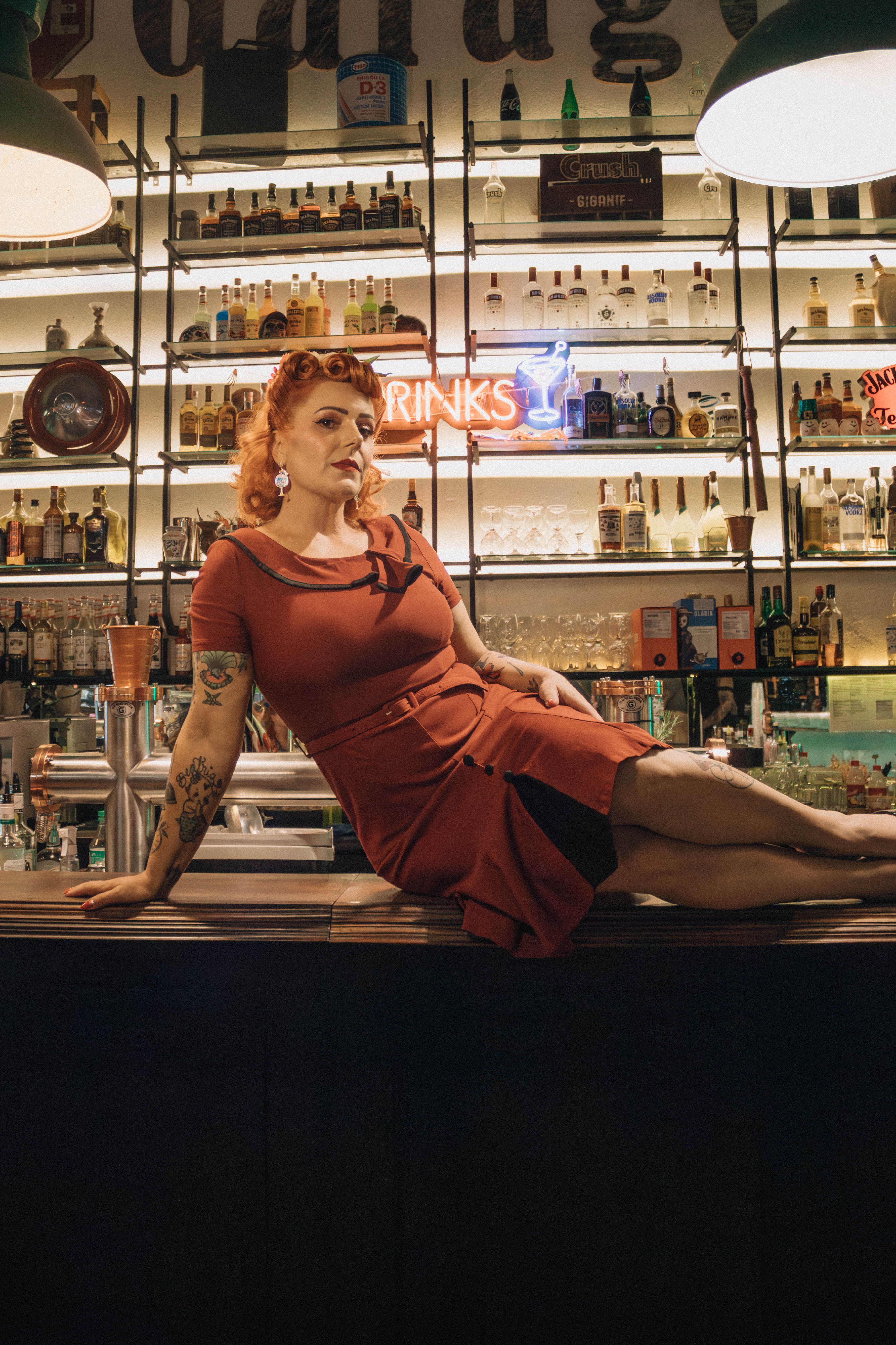 Woman in Red Dress Sitting on Bar Counter · Free Stock Photo