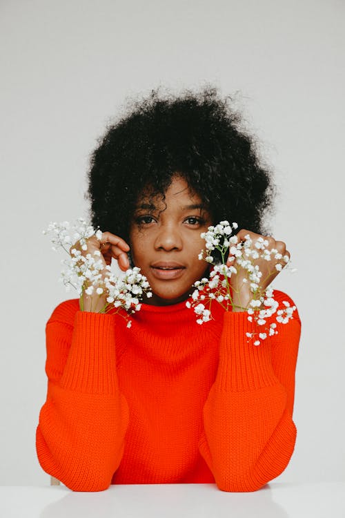 Girl in Red Sweater With White Flower on Her Ear