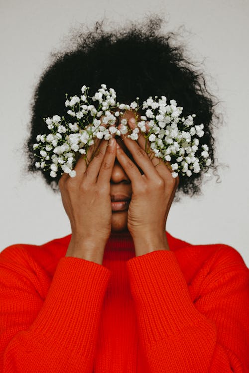 Free Woman in Red Sweater Holding White Flowers Stock Photo