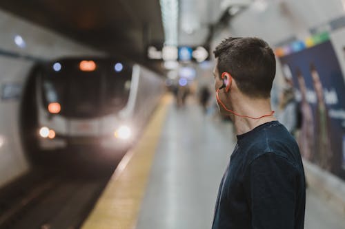 Free Man Using Sports Earphones on Subway Train Stock Photo
