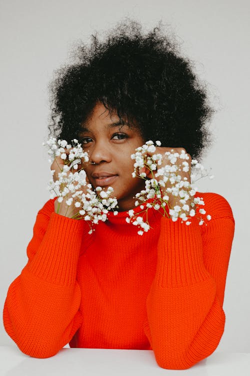 Woman in Red Turtleneck Sweater With White Flower on Her Ear