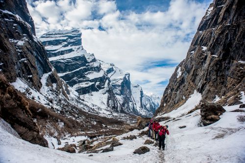 Free Adventure seekers hiking through Nepal's stunning snow-covered mountains. Stock Photo