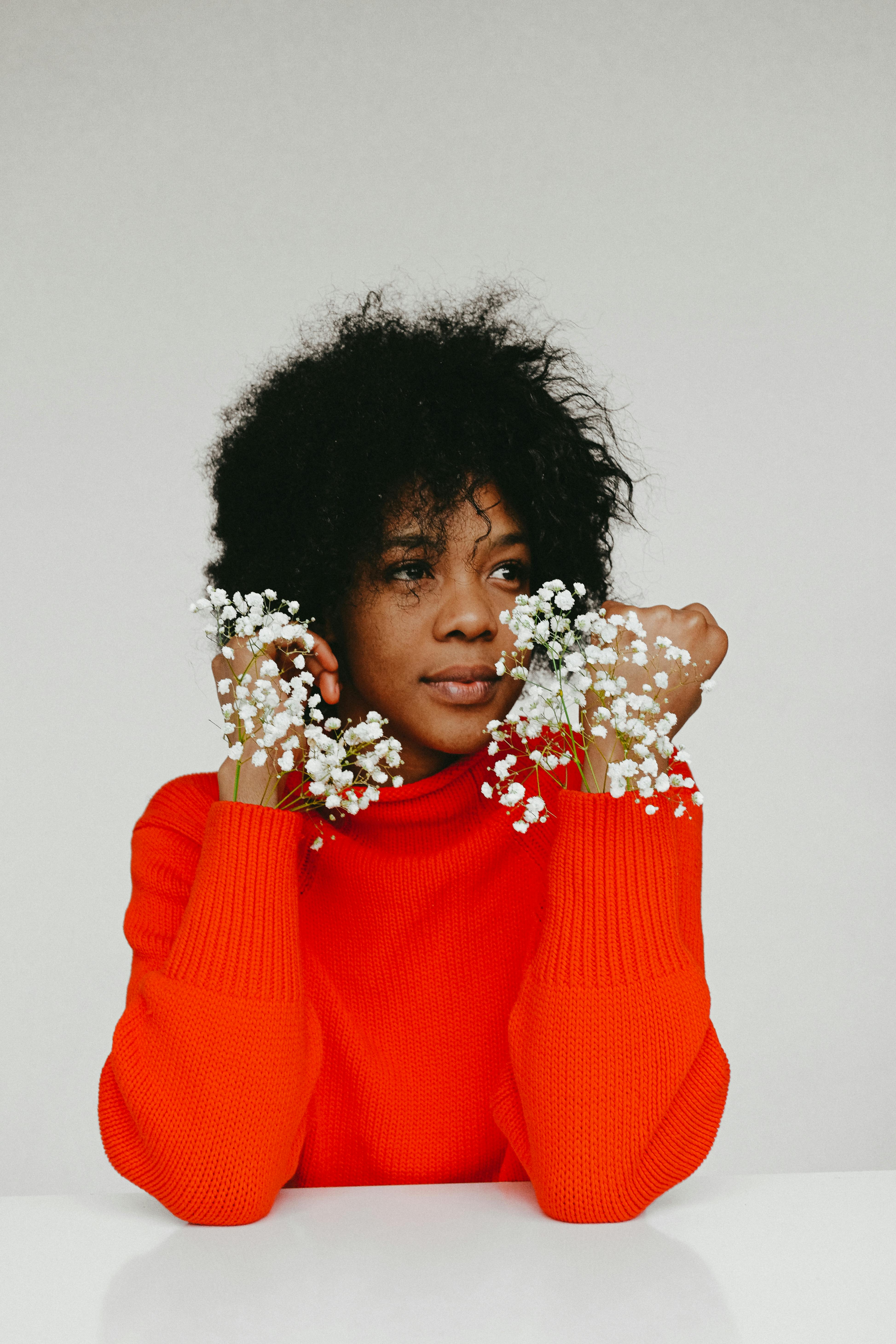 一位身着红色毛衣、点缀着白色花朵的女性时尚肖像