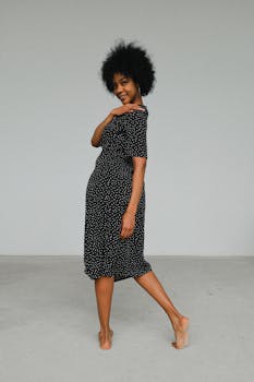 一位身着圆点连衣裙的黑人女性优雅地摆出姿势，散发着自信与魅力